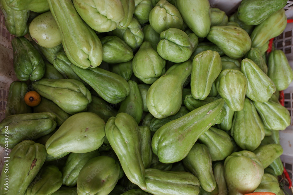 Pile green chayote vegetables on a basket, at a traditional market, stock photo. Pile green chayote vegetables on a basket, at a traditional market, stock photo.