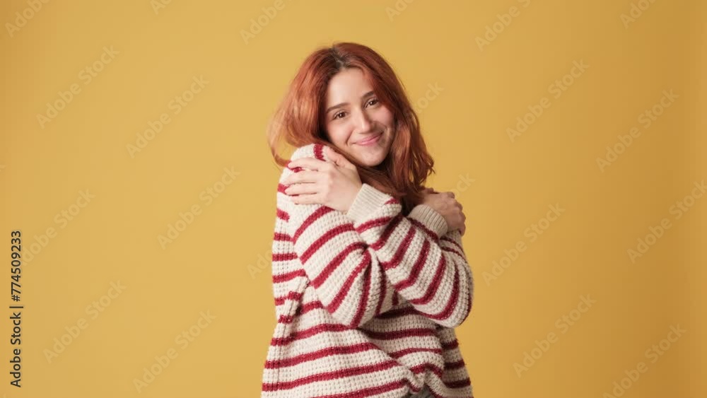 Cute girl hugs herself in studio on yellow background Cute girl hugs herself in studio on yellow background