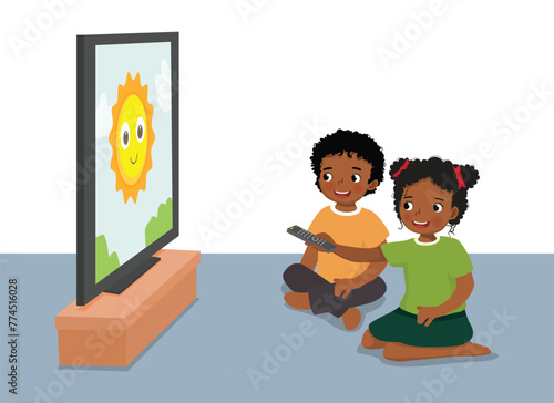 Cute little African kids watching TV sitting on the floor together