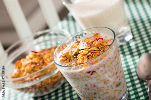 Glass of milk with muesli and dried fruits photo