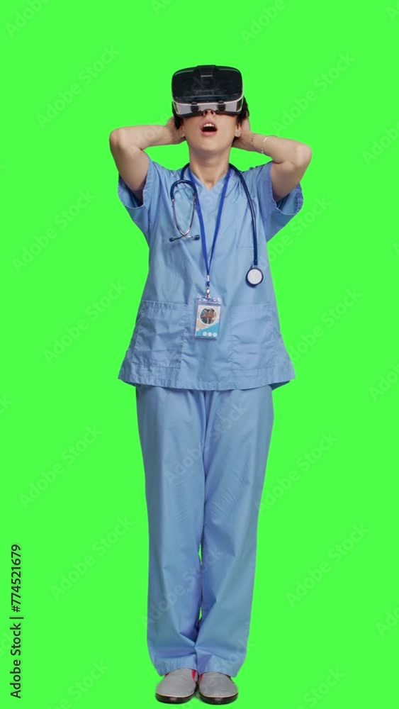 Front view Medical assistant uses interactive vr glasses to check disease treatment, looking at patient examination files with virtual reality headset and lens. Nurse against greenscreen backdrop Front view Medical assistant uses interactive vr glasses to check disease treatment, looking at patient examination files with virtual reality headset and lens. Nurse against greenscreen backdrop