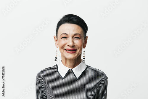 Portrait of a stylish woman in black and white striped shirt and earrings against white background