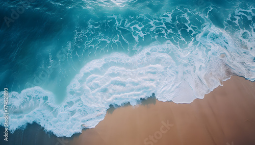 Aerial view showcases a sandy beach near the sea, waves gently lapping the shore