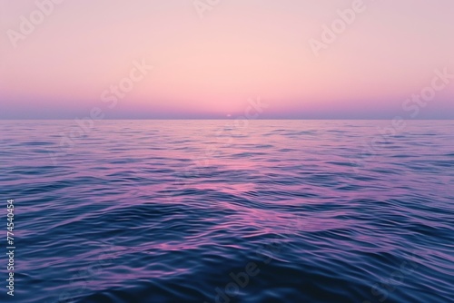 The ocean is calm and the sky is pink