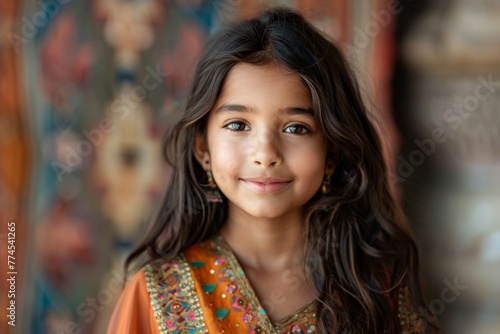 A young girl with long brown hair and a bright smile