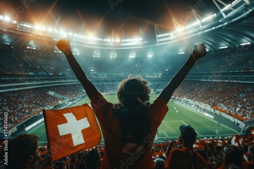 A woman is holding a flag in a stadium full of people. Football fan at the football championship