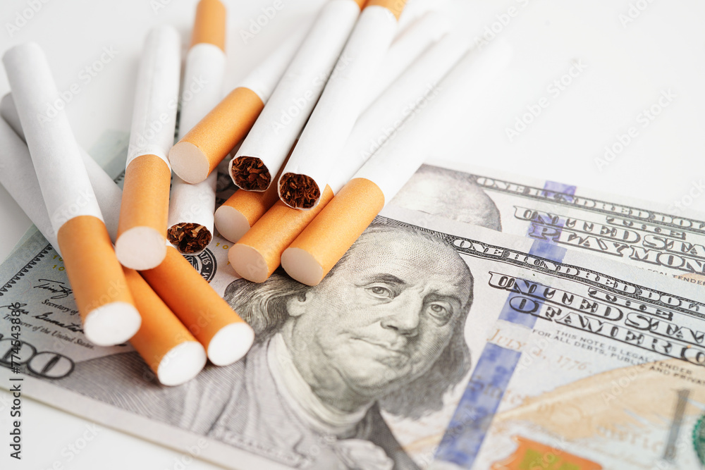 Cigarette on US dollar banknotes, cost, trading, marketing and production, No smoking concept. Cigarette on US dollar banknotes, cost, trading, marketing and production, No smoking concept.