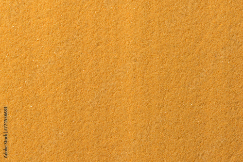 Monochrome sandy background of yellow sea sand.