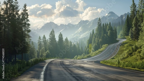 Serpentine road winding through a lush green forest, with majestic sunlit mountains in the background under a blue sky with fluffy clouds. photo
