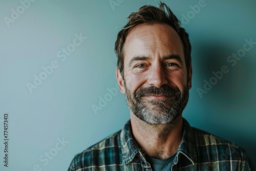 Portrait of a handsome man with a beard and mustache in a checkered shirt