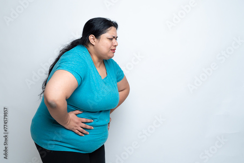 Overweight fat indian woman hand on stomach felling unwell because of indigestion ache. isolated over white background. Plus size female. Healthcare Concept. Copy Space photo