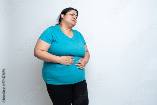 Overweight fat indian woman hand on stomach felling unwell because of indigestion ache. isolated over white background. Plus size female. Healthcare Concept. Copy Space