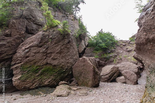 haute falaise érodée avec des grosses roches et des arbres au sommet lors d'une journée ennuagée d'été photo