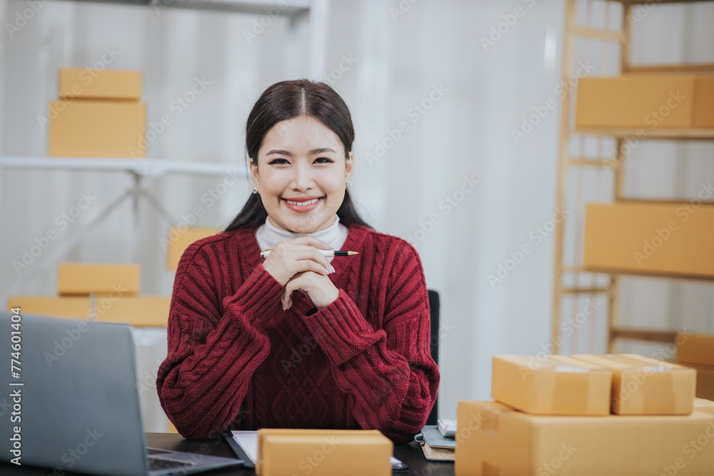 Small business entrepreneurSME Independent Asian woman using laptop with box Cheerful successful Asian woman Online marketing and SME delivery ideas Small business entrepreneurSME Independent Asian woman using laptop with box Cheerful successful Asian woman Online marketing and SME delivery ideas
