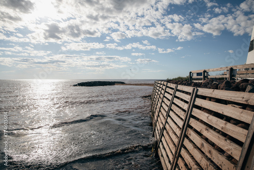 vue sur une structure en bois en bord de mer qui protège la rive des vagues en été lors d'une journée ensoleillée
