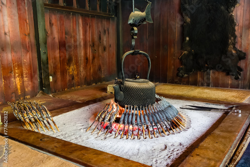 Traditional Japanese fireplace in a mountain hut cooking freshly caught Iwana (Grilled Char) photo