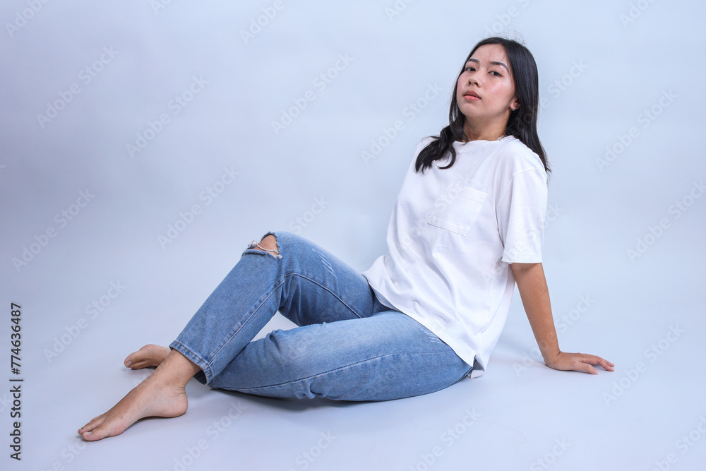 Young Asian girl sitting and wearing blank white t-shirt.