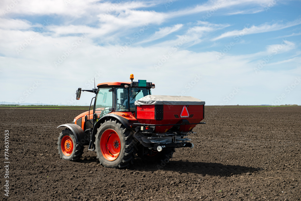 Obraz premium Tractor spreading artificial fertilizers
