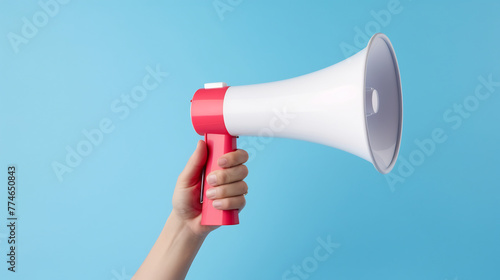 Hand Holding a Red and White Megaphone Against a Blue Background, Communication and Announcement Concept, Speaking Out