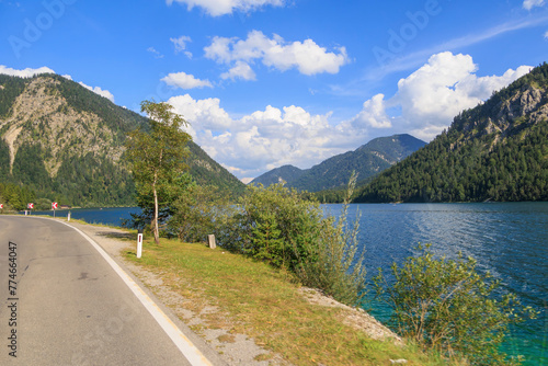 Road on the shore of Plansee lake in Austria on a sunny day with blue sky