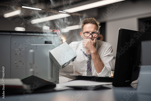 Unqualified minded office worker trying to fix his smoking after breakdown, DIY mastery: Office worker showcases self-reliance in tackling computer issues