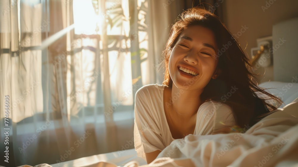 A Happy half Asian woman getting out of bed in the morning laughing. Happiness, waking up, relaxing, welcoming the new day. - obrazy, fototapety, plakaty 