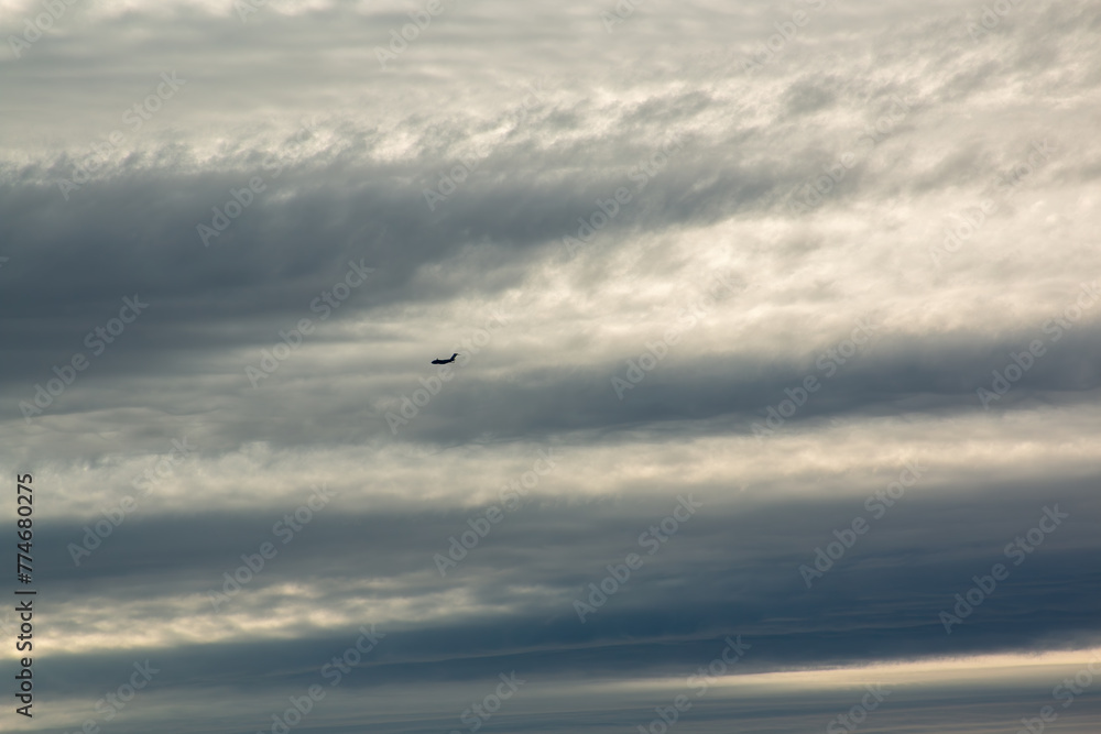 A military transport jet against a cloudy sky over Seattle