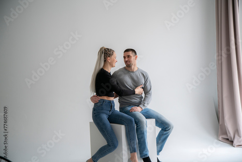 Portrait of a White Serene Couple Embracing in a Tender Moment Against a Neutral Background