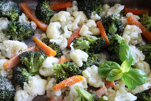 Sfondo con broccoli al forno, cavolfiori, carote ed erbe aromatiche. Cibo sano e vegetariano. Vista dall'alto.