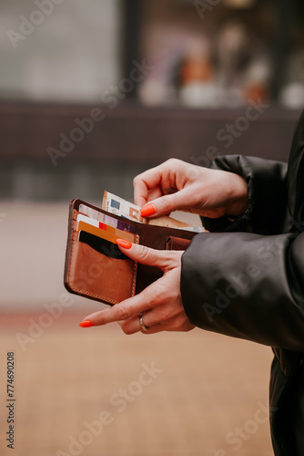 Woman hands taking money out of leather wallet