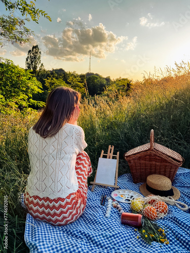 Painter's paradise: woman creates art during a picnic. © phpetrunina14
