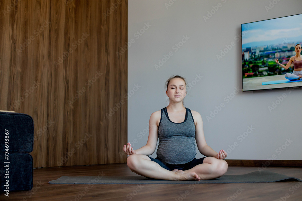 Pregnant woman practicing yoga at home