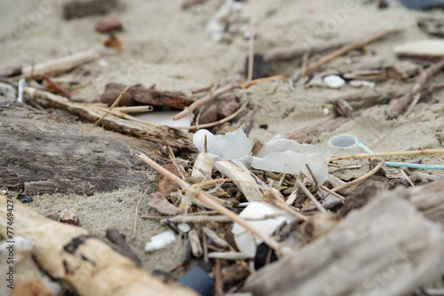 Déchets plastiques et divers objets sur le sable en bord de plage. Détritus sur la plage.  photo