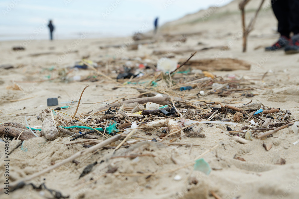 Déchets plastiques et divers objets sur le sable en bord de plage. Détritus sur la plage. 