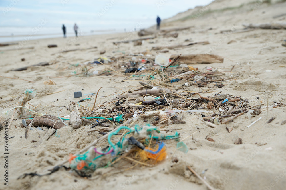 Déchets plastiques et divers objets sur le sable en bord de plage. Détritus sur la plage. 