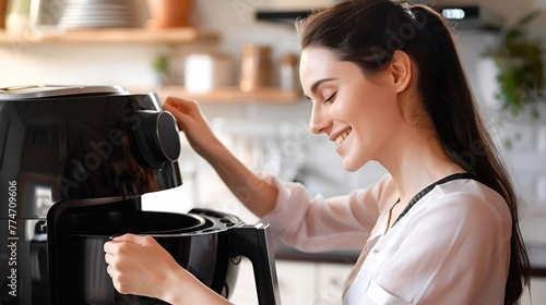 Smiling woman cooks food with modern electric air fryer