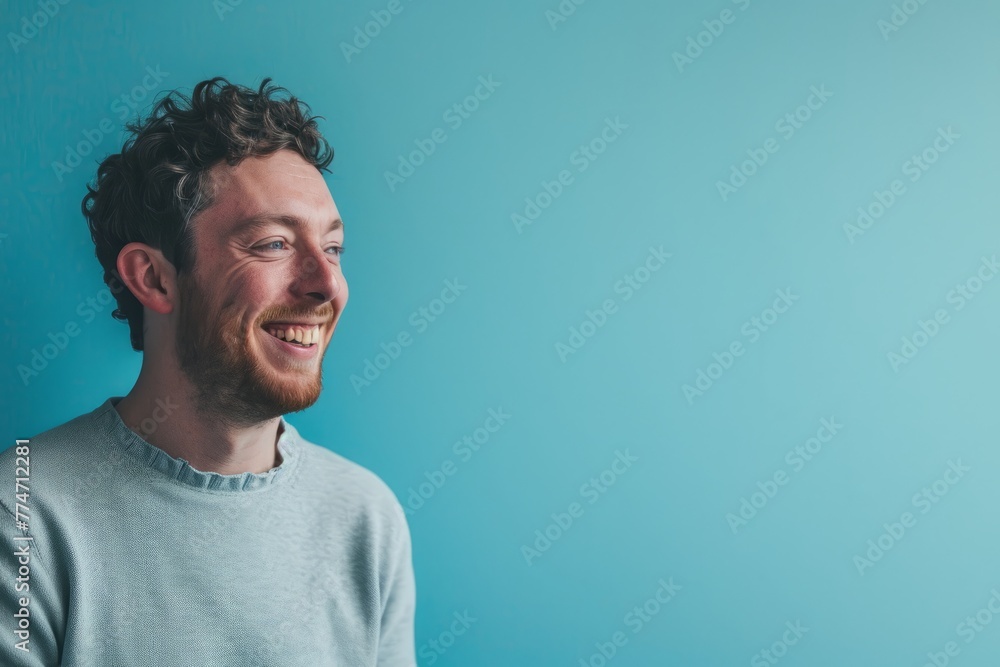 Portrait of a happy young man laughing on a blue background. Portrait of a happy young man laughing on a blue background.