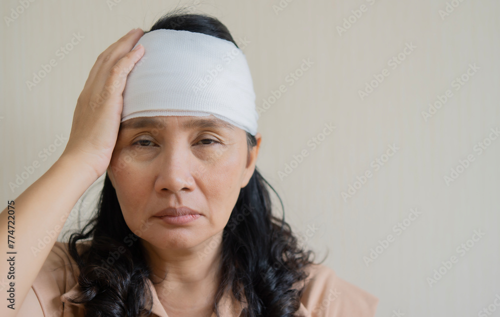 White bandage on Asian woman brain concussion wound head. Close-up White bandage on Asian woman brain concussion wound head. Close-up