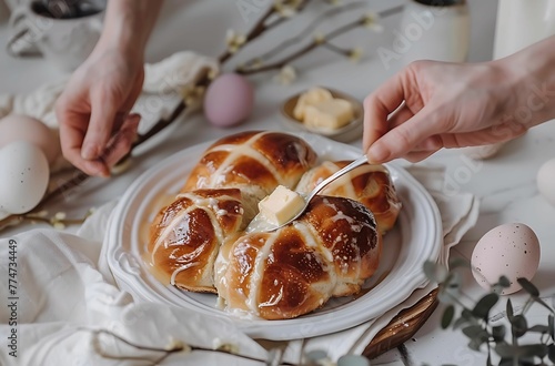 food photography of hot cross buns on white table, easter decorations and hand holding an egg in the background,