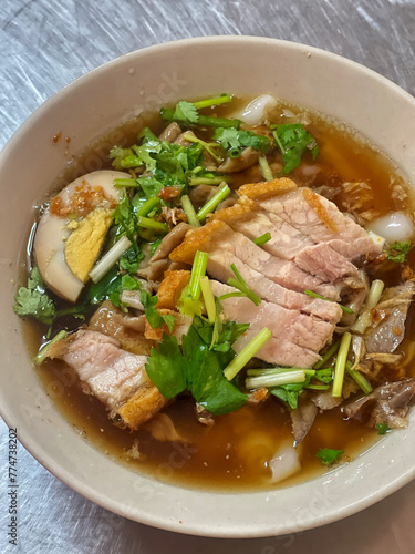 Rolled Rice Noodles in Five-spices Broth, sweet flavor with Chinese spices. The soup is black of stewed water. Ingredients are pork offal, pork blood and boiled egg