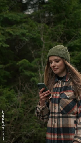 Portrait of young hiker woman using mobile phone navigation or social media app