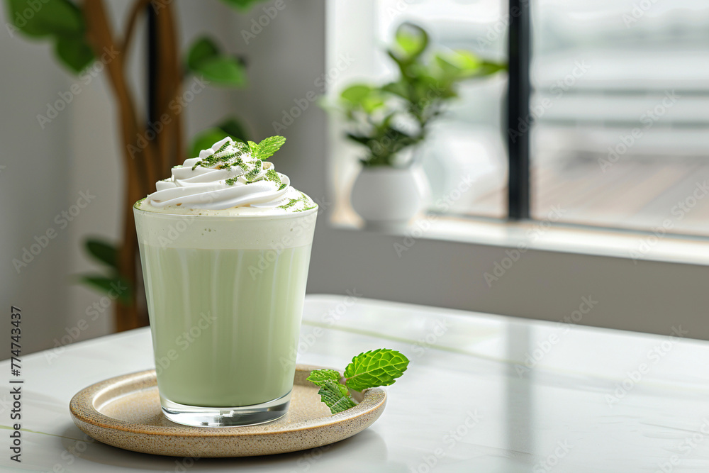Glass with matcha milk cocktail with mint leaves on a white table in a cafe. Healthy lifestyle. Glass with matcha milk cocktail with mint leaves on a white table in a cafe. Healthy lifestyle.