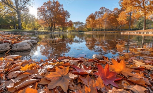 A beautiful autumn scene with a lake and trees. The leaves on the ground are orange and the water is calm photo