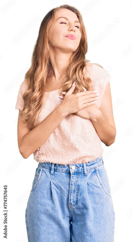 Young beautiful caucasian woman with blond hair wearing casual clothes smiling with hands on chest with closed eyes and grateful gesture on face. health concept. Young beautiful caucasian woman with blond hair wearing casual clothes smiling with hands on chest with closed eyes and grateful gesture on face. health concept.