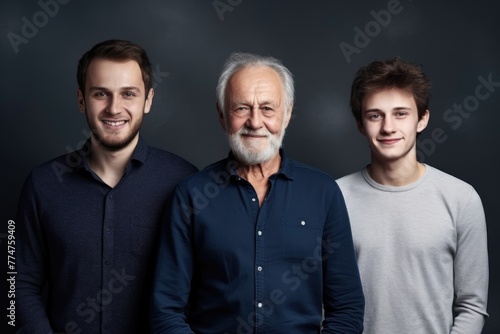 A heartwarming family portrait featuring a senior man, adult son, and teenage grandson smiling together. Multi-Generation Family Portrait with Grandfather
