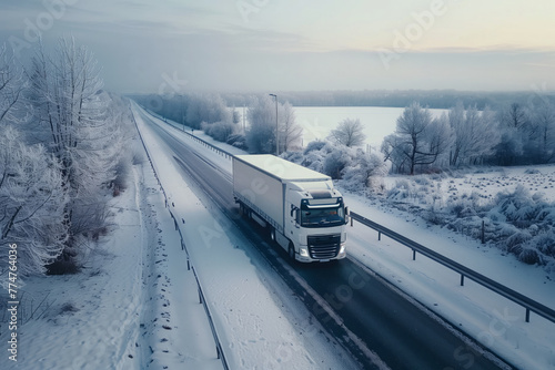 A delivery truck driving along the road against the backdrop of winter nature. Bird's eye view.