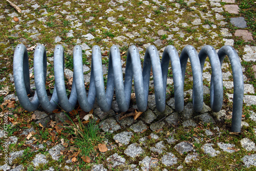 Metal spiral of empty bike stand on a bicycle parking lot