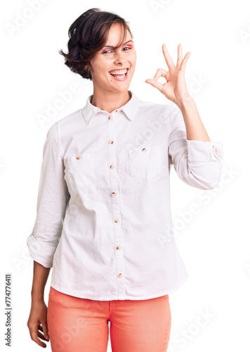 Beautiful young woman with short hair wearing elegant white shirt smiling positive doing ok sign with hand and fingers. successful expression.