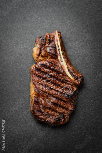 Steak. Grilled steak on the bone. Roasted piece of meat. Free space for text. © Yaruniv-Studio