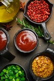 A set of sauces in sauce pans and spices. Sauces for meat and fish.
